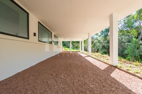 Zeitgenössische Villa in einer sehr schönen und natürlichen Umgebung von Sotogrande Alto, mit Blick auf eine Grünfläche.